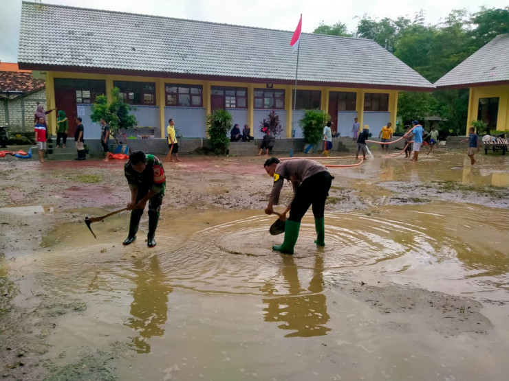 Gotong Royong Polisi dan TNI bersama Warga Bersihkan Sisa Meterial Banjir di Tuban